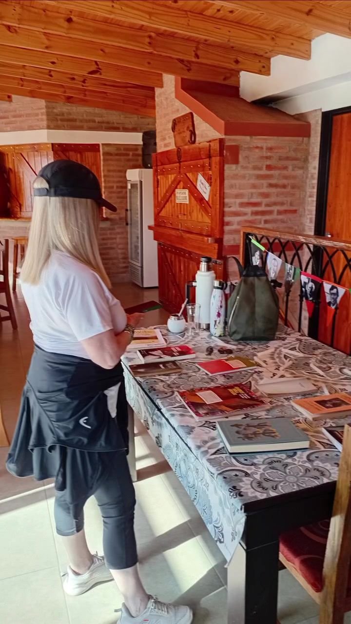 Mesa larga en un salón de techo de madera, con participantes trabajando en un taller.